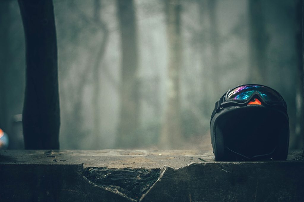 open face helmet with some goggles strapped to it. 
