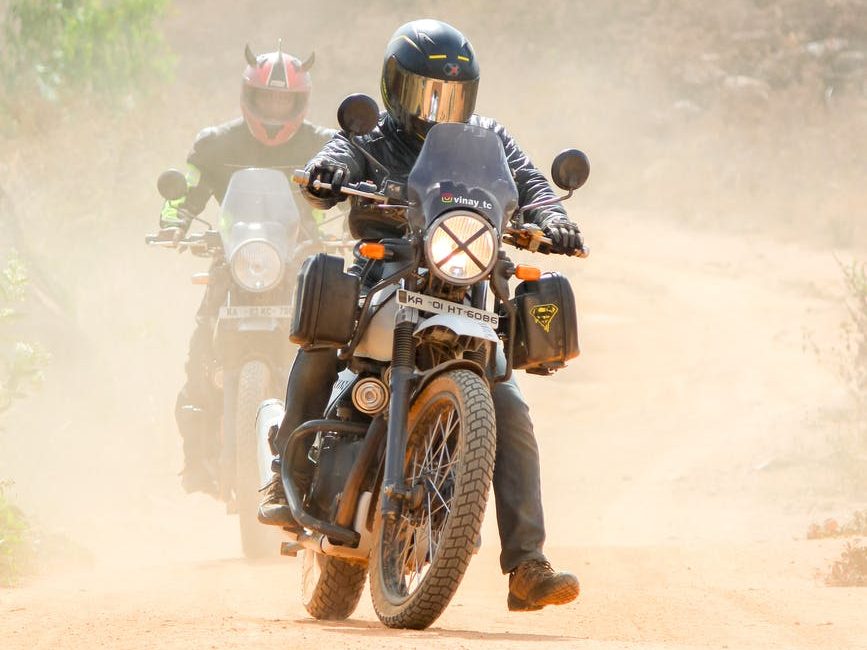 man riding motorcycle on dirt road doing some adventure touring riding