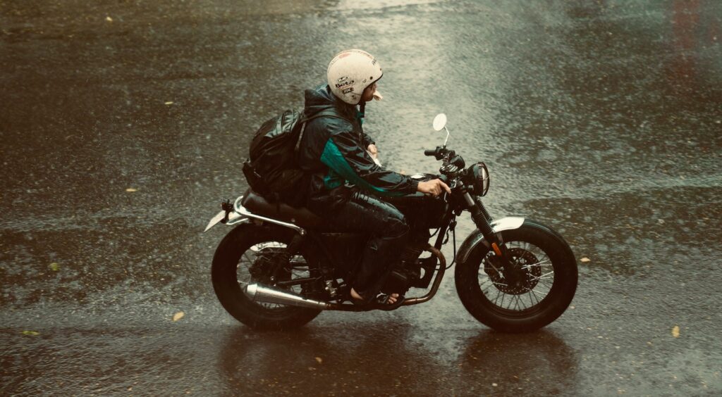 A motorcyclist riding in the rain wearing one of the best motorcycle rain jackets.