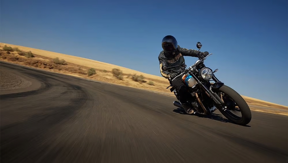 a rider wearing a safe motorcycle helmet while riding a Triumph Speed Twin 900.