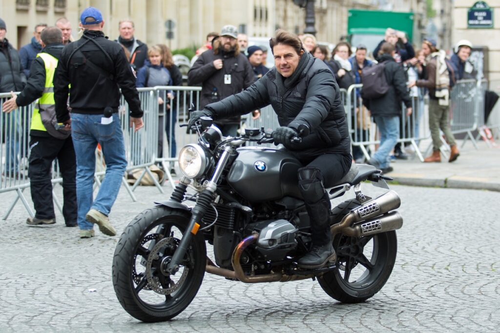 Tom Cruise riding a BMW R nineT motorcycle on the set of Mission: Impossible – Fallout in Paris, France.