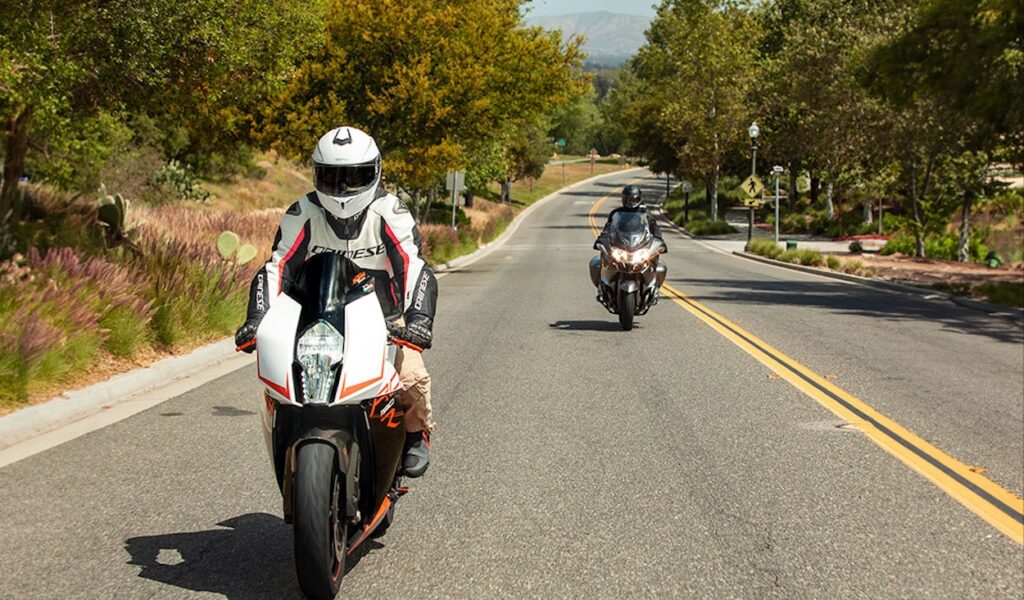 Two motorcyclists wearing Sena motorcycle helmets with Bluetooth intercoms