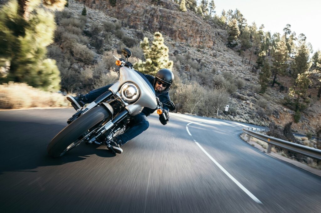 A motorcyclist riding a Harley on a canyon road.