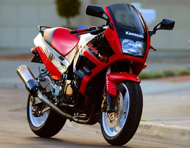 A red second-generation Kawasaki Ninja 250R parked on the street.