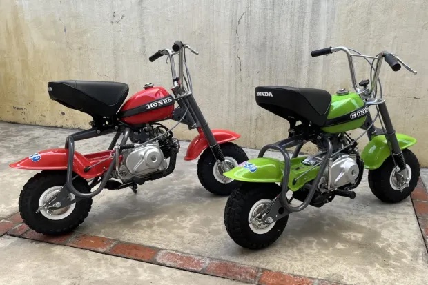 Two 1971 Honda Q50s next to each other that are for sale at Bring a Trailer