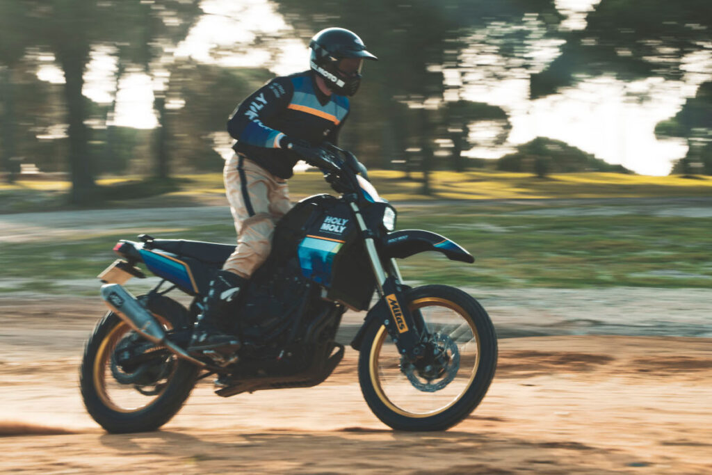 Retro Custom Yamaha T7 by Holy Moly Motorcycles speeding through the dirt