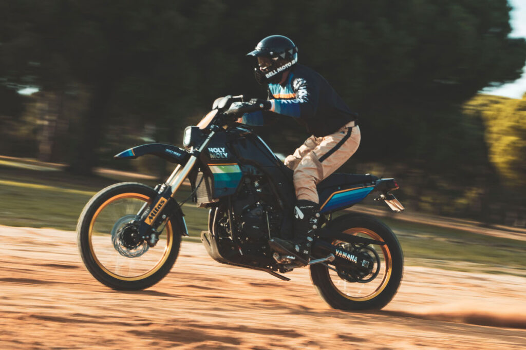 Retro Custom Yamaha T7 by Holy Moly Motorcycles riding in the dirt