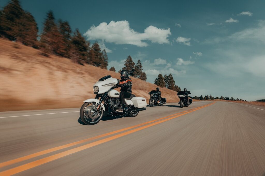 Three harley-davidson motorcycles on a highway.