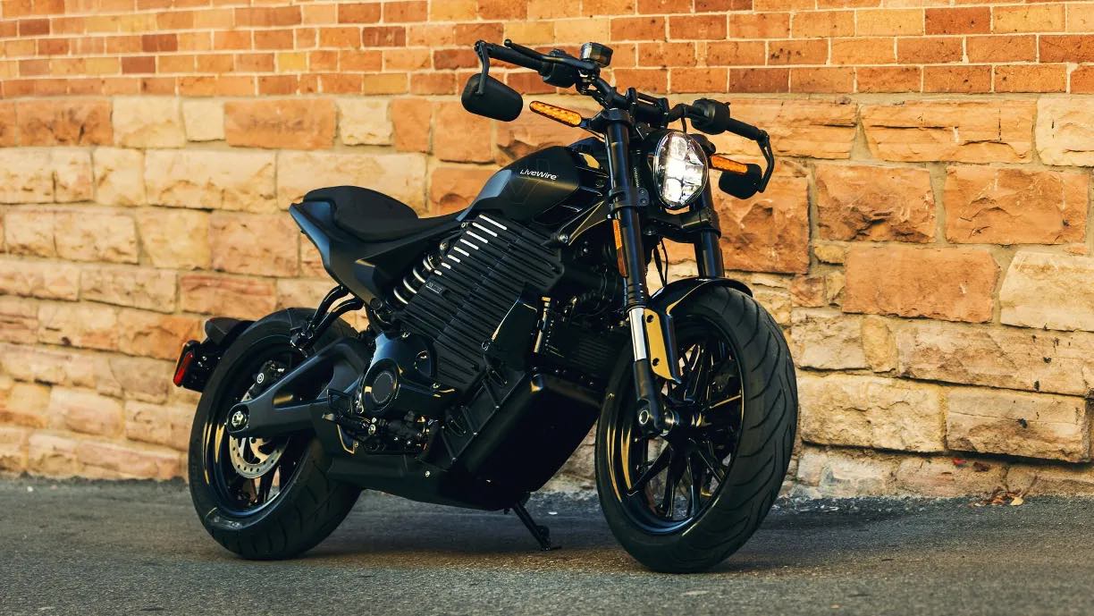 The 2025 LiveWire S2 Alpinista electric motorcycle parked in front of a brick wall.