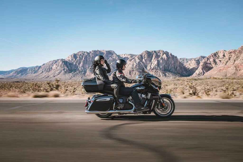 2025 Indian Roadmaster Powerplus motorcycle riding on a highway with two riders.