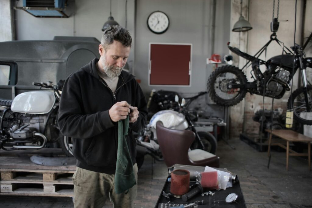 A man working on motorcycles in his garage