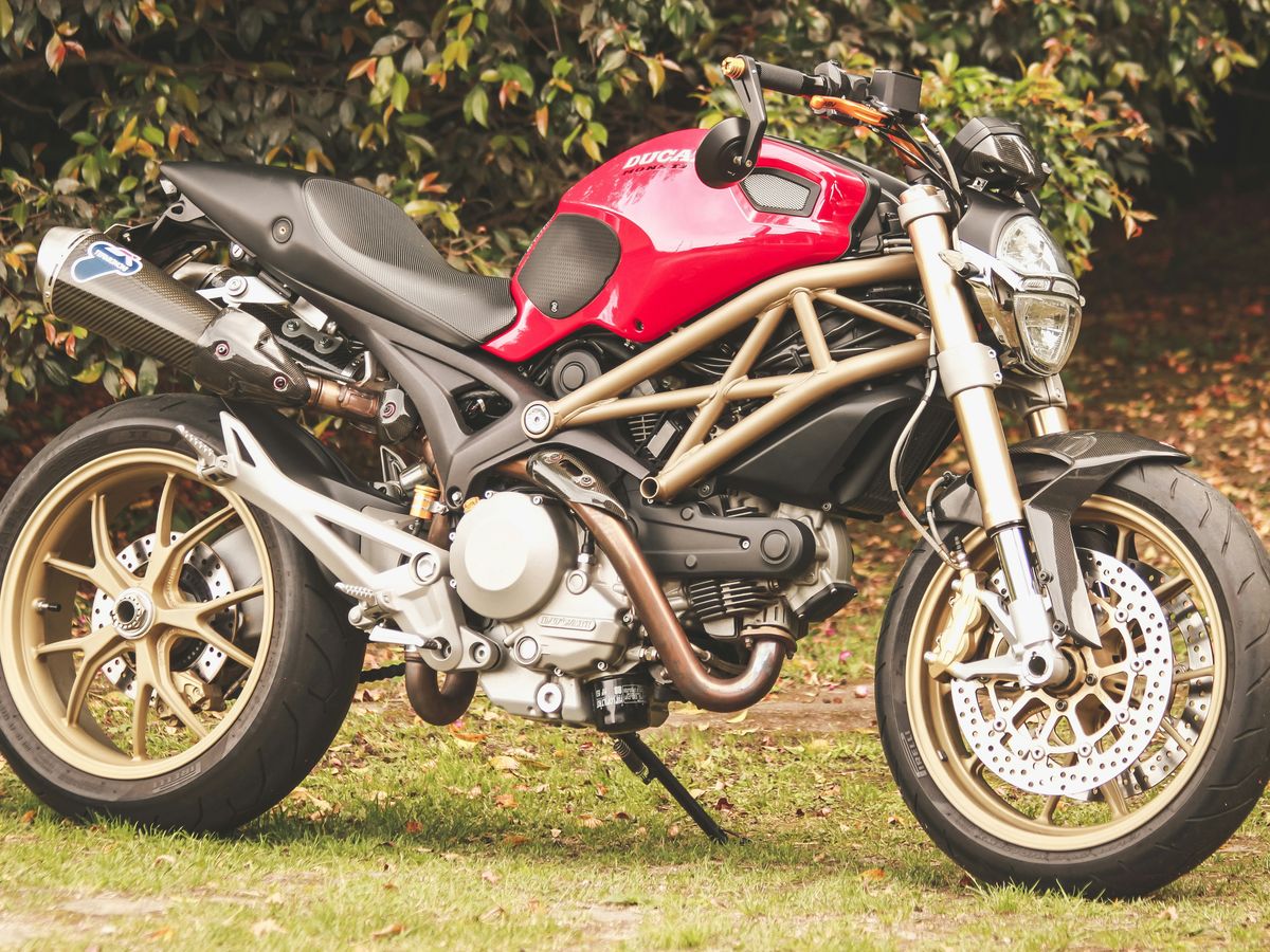 red and black motorcycle on green grass field during daytime