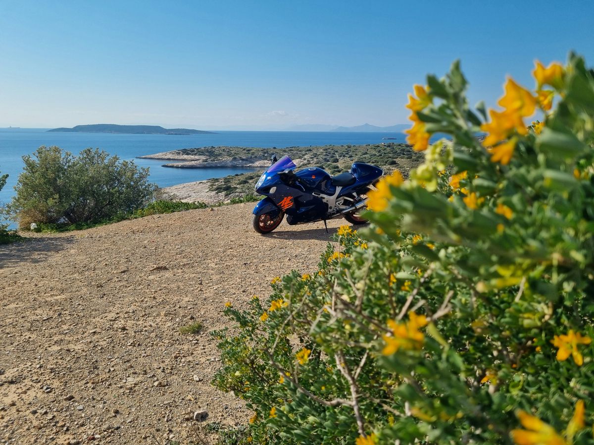 A motorcycle parked on the side of a dirt road