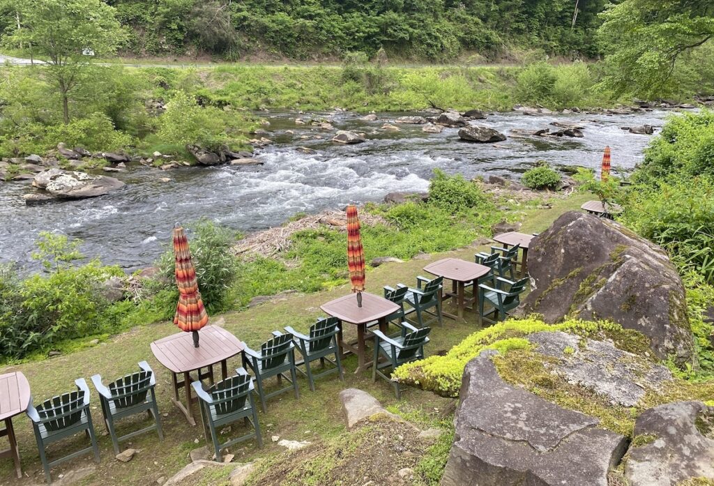 Tables and outdoor fire pits next to Cheoah river at Tapoco Lodge
