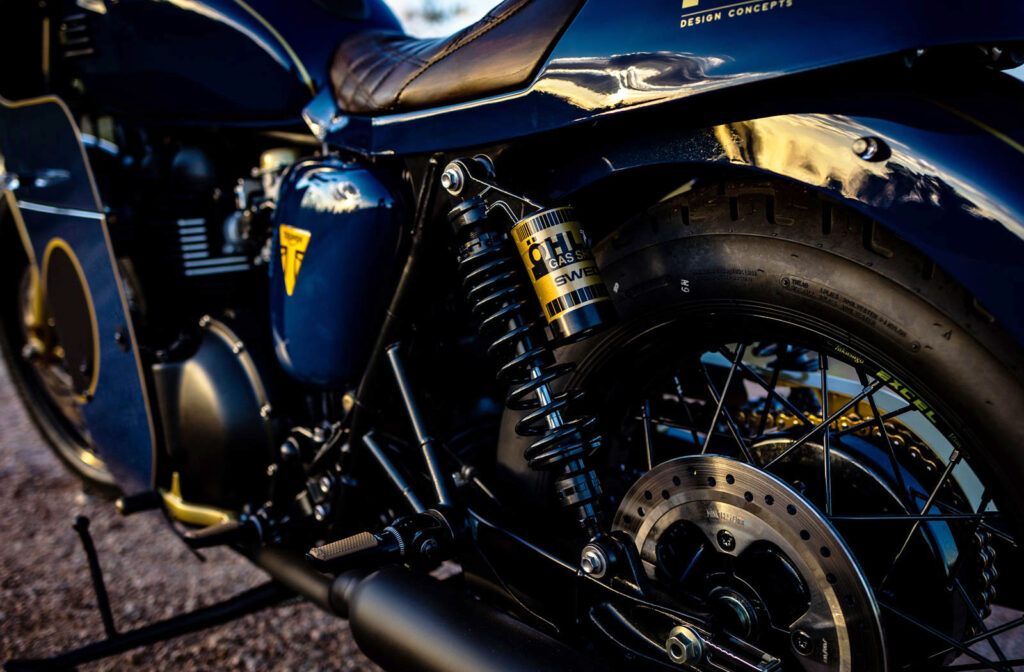 The rear shocks and wheel of the Custom Triumph Bonneville T100 Cafe Racer by MB Design Concepts
