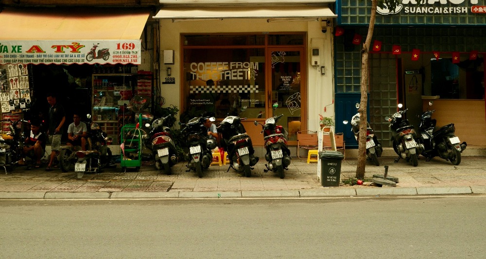 Motorcycles and scooters parked outside a coffee shop