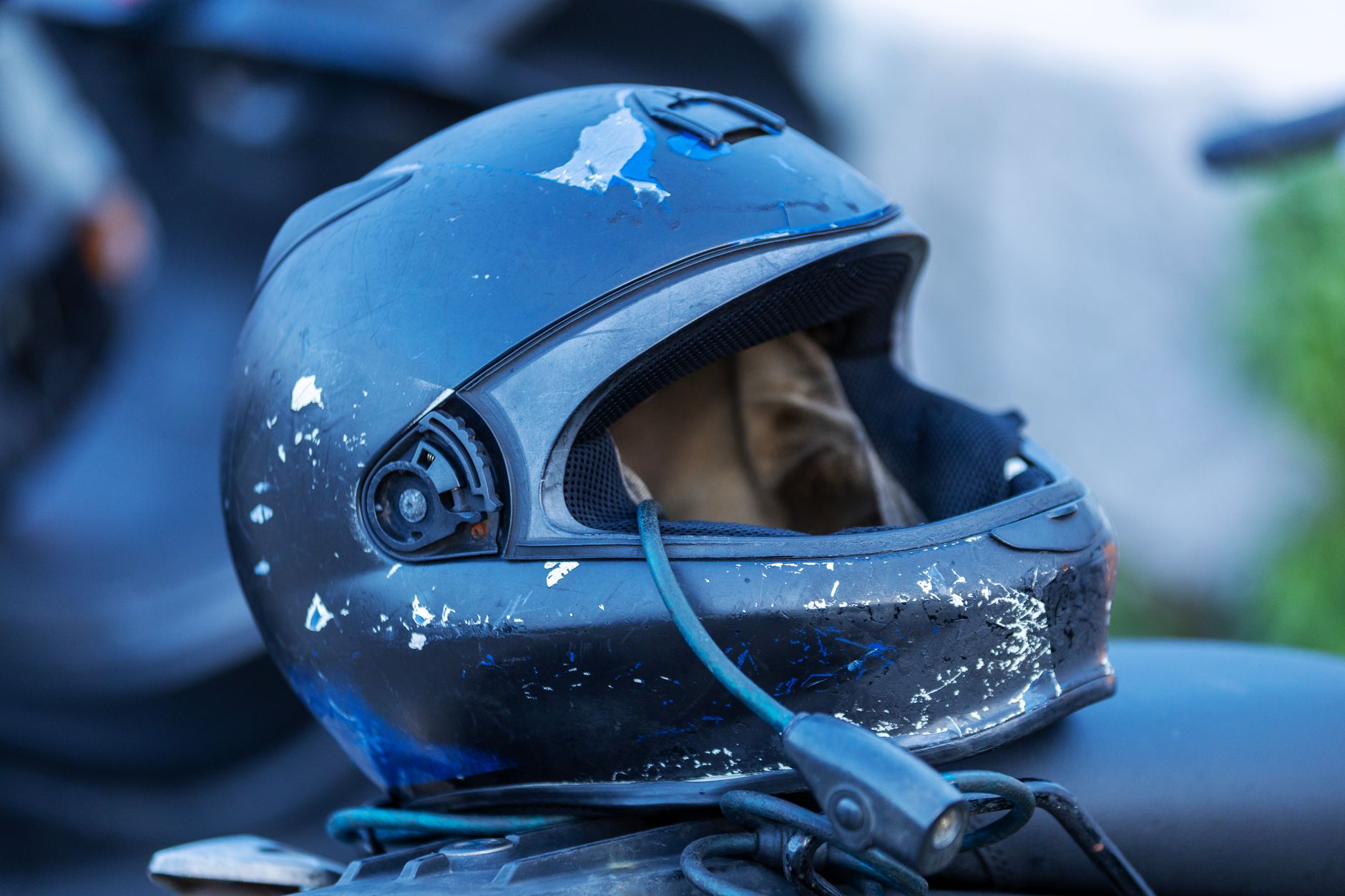 Detailed close-up of a worn motorcycle helmet highlighting its rugged and scratched exterior.