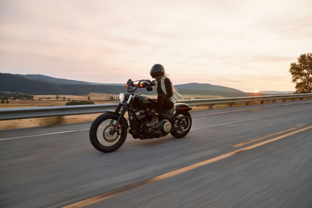 A motorcycle rider alone on the road during a road trip.